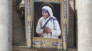 FILE - In this Thursday, Sept. 1, 2016 file photo, a tapestry showing Mother Teresa hangs from the central balcony of St. Peter's Basilica, in St. Peter's Square, at the Vatican. For many of the poor and destitute whom Mother Teresa served, the tiny nun was a living saint. Many at the Vatican would agree, but the Catholic Church nevertheless has a grueling process to make it official, involving volumes of historical research, the hunt for miracles and teams of experts to weigh the evidence. (AP Photo/Alessandra Tarantino, File)